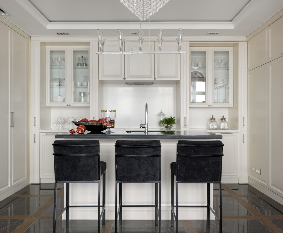トランジショナルスタイルのおしゃれなキッチン (アンダーカウンターシンク、落し込みパネル扉のキャビネット、白いキャビネット、白いキッチンパネル、パネルと同色の調理設備、マルチカラーの床、黒いキッチンカウンター) の写真