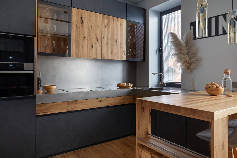 Inredning av ett mellanstort grå grått kök, med en enkel diskho, bruna skåp, bänkskiva i rostfritt stål, grått stänkskydd, integrerade vitvaror och en köksö