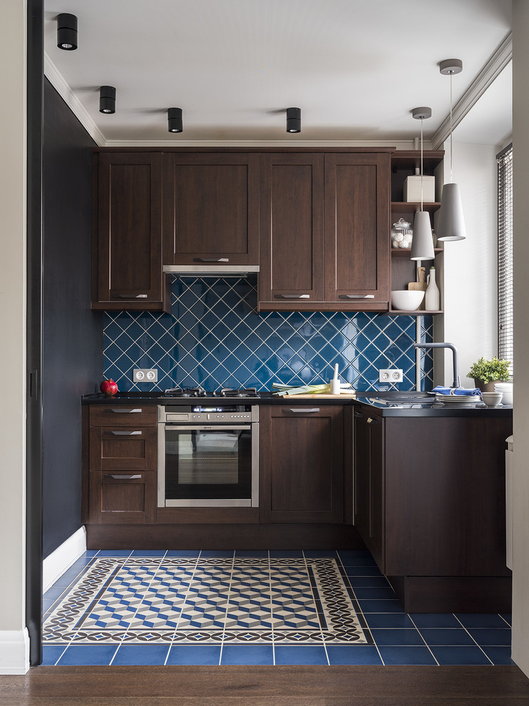 モスクワにあるお手頃価格の小さなコンテンポラリースタイルのおしゃれなL型キッチン (シングルシンク、濃色木目調キャビネット、人工大理石カウンター、セラミックタイルのキッチンパネル、シルバーの調理設備、セラミックタイルの床、青い床、落し込みパネル扉のキャビネット、青いキッチンパネル、アイランドなし、黒いキッチンカウンター) の写真