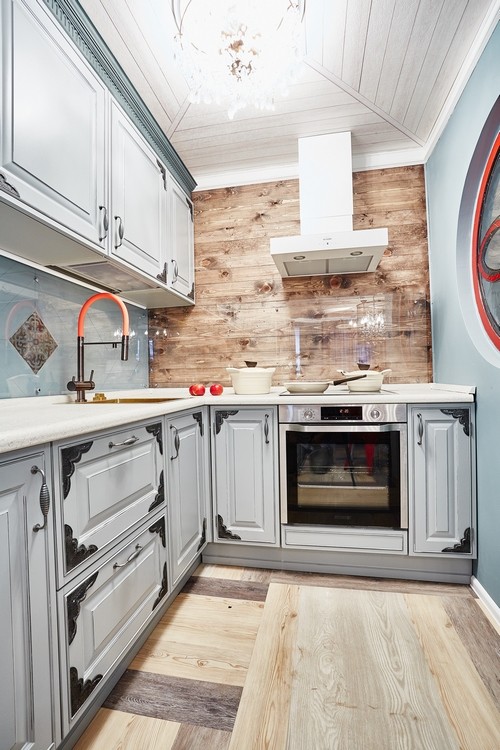 На фото: угловая кухня среднего размера в стиле лофт с фасадами с выступающей филенкой и зелеными фасадами с