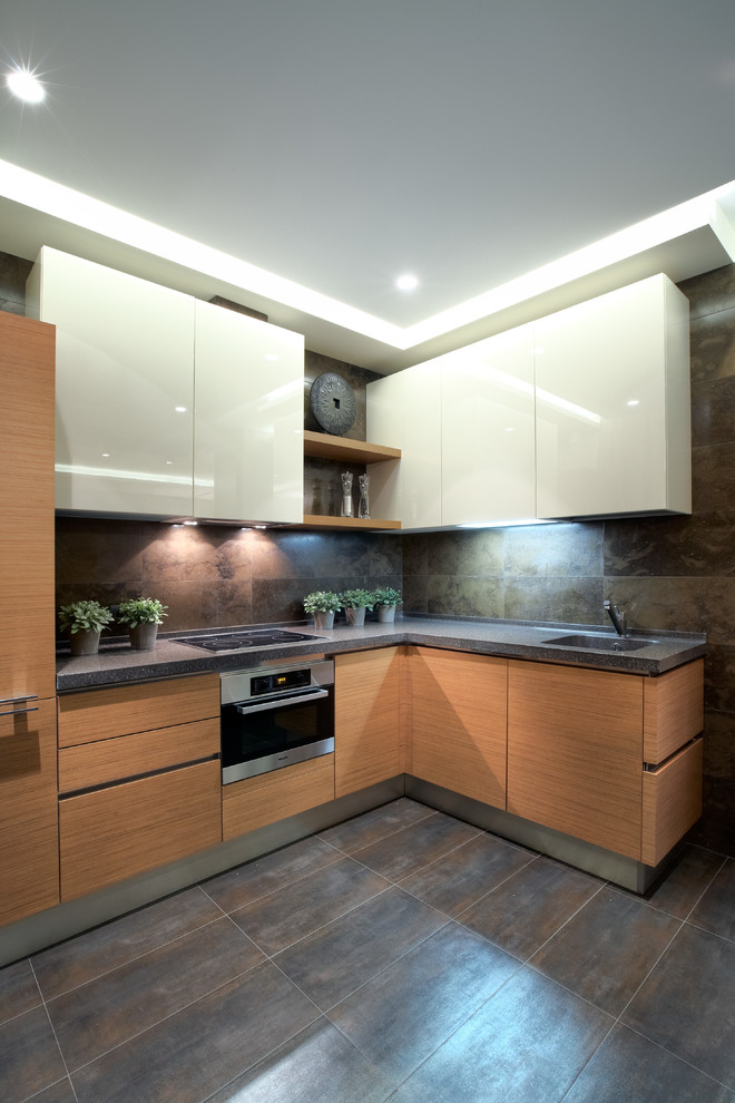 Small contemporary l-shaped open plan kitchen in Moscow with flat-panel cabinets, medium wood cabinets, composite countertops, brown splashback, stone tiled splashback, porcelain flooring, no island and stainless steel appliances.