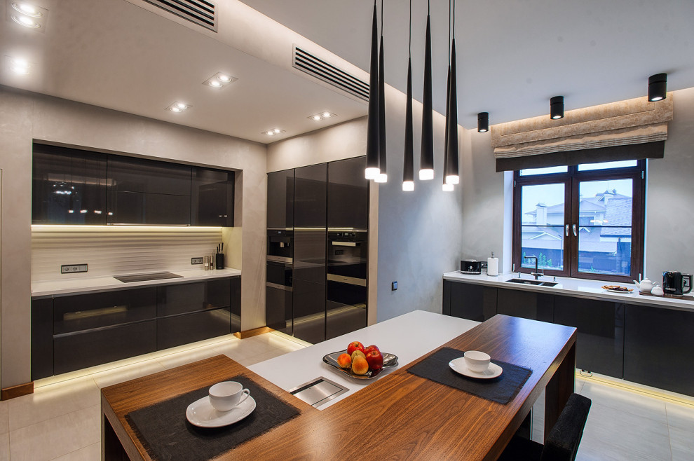 Esempio di una grande cucina contemporanea con lavello sottopiano, ante lisce, ante nere, paraspruzzi bianco, elettrodomestici da incasso, pavimento beige e top bianco