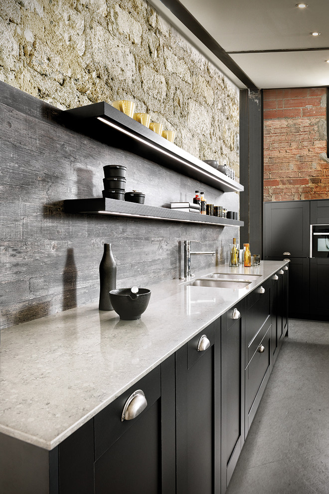 Example of an urban single-wall concrete floor open concept kitchen design in Moscow with an undermount sink, recessed-panel cabinets, black cabinets, quartz countertops, black backsplash, black appliances and two islands