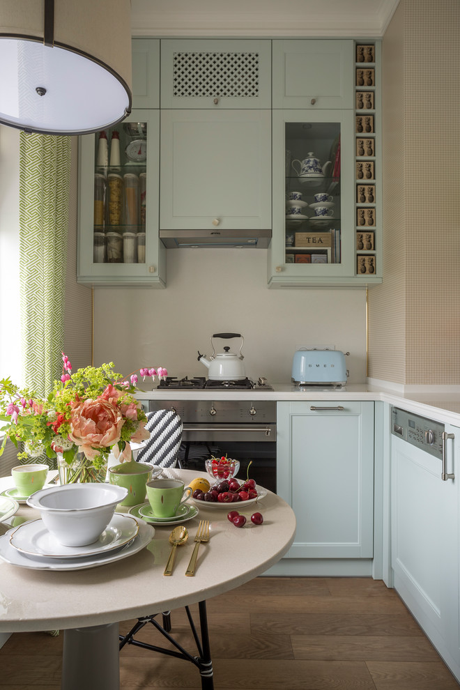 Inspiration för ett avskilt, litet vintage l-kök, med luckor med infälld panel, vitt stänkskydd, rostfria vitvaror och brunt golv