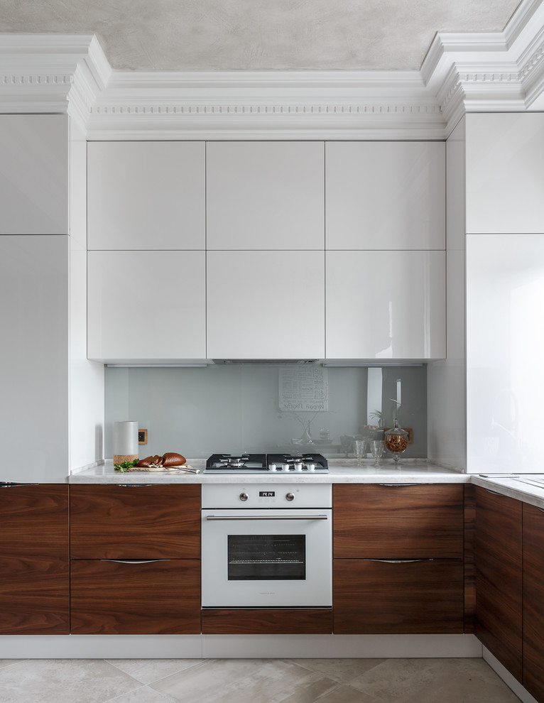 Moderne Küche in L-Form mit flächenbündigen Schrankfronten, weißen Schränken, Küchenrückwand in Grau, Glasrückwand, weißen Elektrogeräten, beigem Boden und weißer Arbeitsplatte in Moskau