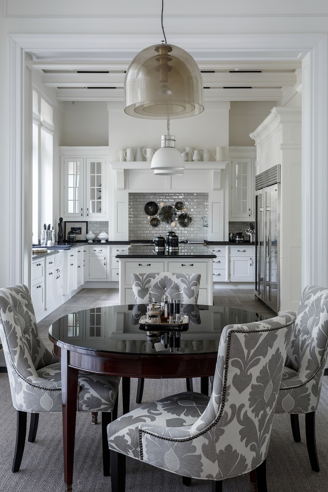 Example of a classic eat-in kitchen design in Moscow with white cabinets, white backsplash, subway tile backsplash and an island