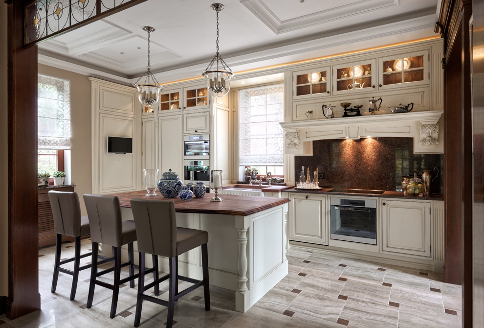 Inspiration for a classic l-shaped kitchen in Moscow with a belfast sink, raised-panel cabinets, white cabinets, brown splashback, stainless steel appliances, an island and grey floors.