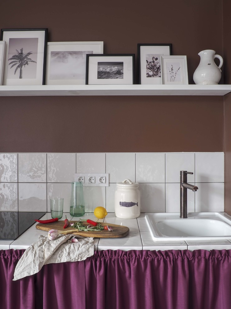 Foto på ett funkis vit linjärt kök med öppen planlösning, med en nedsänkt diskho, öppna hyllor, lila skåp, kaklad bänkskiva, vitt stänkskydd, stänkskydd i keramik och vitt golv