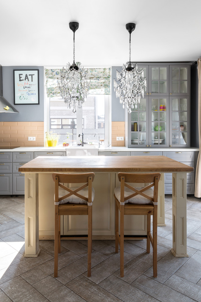 Inspiration för klassiska vitt kök med öppen planlösning, med en rustik diskho, luckor med upphöjd panel, blå skåp, orange stänkskydd, stänkskydd i tunnelbanekakel, rostfria vitvaror, en köksö och grått golv