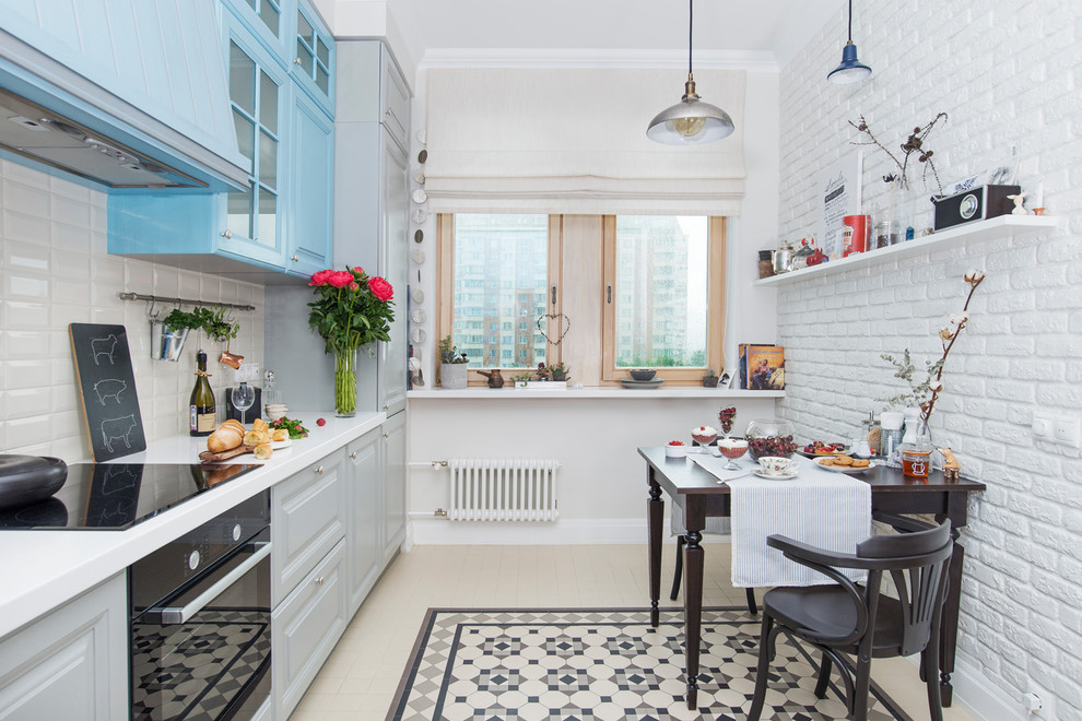 Large traditional l-shaped kitchen/diner in Moscow with raised-panel cabinets, blue cabinets, white splashback, metro tiled splashback, black appliances, no island and beige floors.