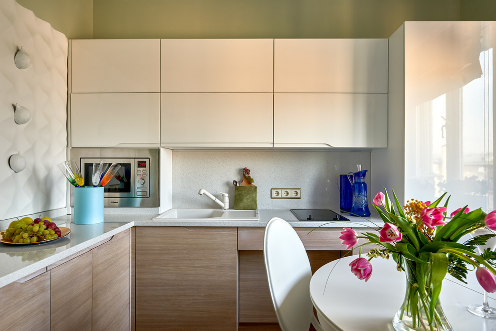 Imagen de cocinas en L actual cerrada sin isla con fregadero encastrado, armarios con paneles lisos y salpicadero verde