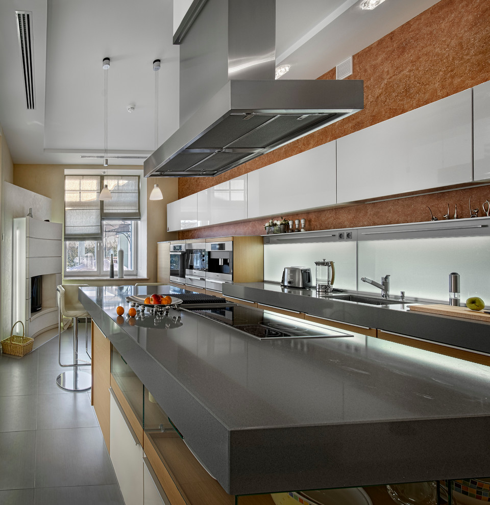 На фото: кухня в современном стиле с одинарной мойкой, плоскими фасадами, техникой из нержавеющей стали и островом с