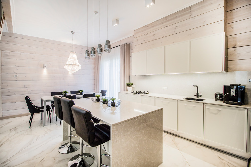 Idéer för ett modernt beige linjärt kök och matrum, med en undermonterad diskho, släta luckor, vita skåp, vitt stänkskydd, en köksö och vitt golv