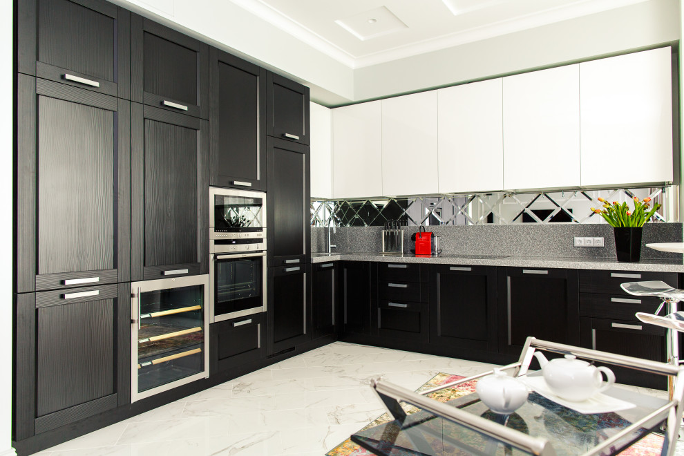 Esempio di una cucina a L design con ante con riquadro incassato, ante nere, elettrodomestici in acciaio inossidabile, nessuna isola, pavimento bianco e top grigio