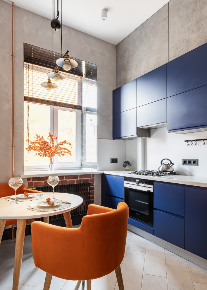 Источник вдохновения для домашнего уюта: кухня в стиле лофт с плоскими фасадами, синими фасадами, белым фартуком, черной техникой, бежевым полом и белой столешницей