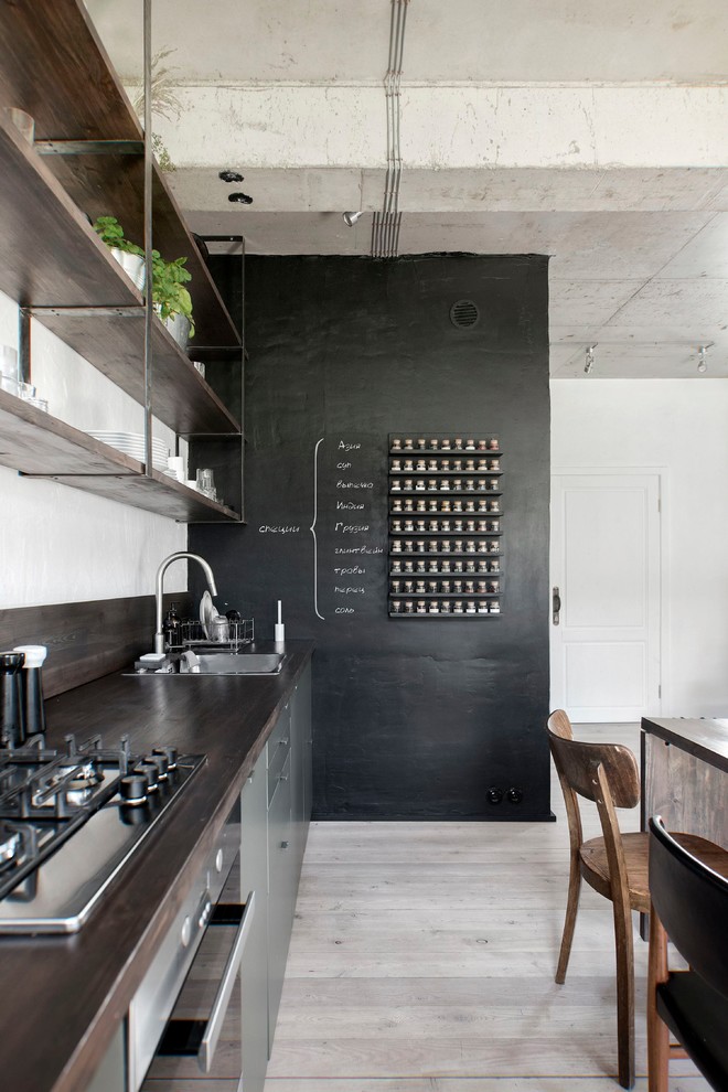 Bild på ett litet industriellt brun linjärt brunt kök och matrum, med släta luckor, träbänkskiva, brunt stänkskydd, stänkskydd i trä, målat trägolv, en enkel diskho, rostfria vitvaror och beiget golv