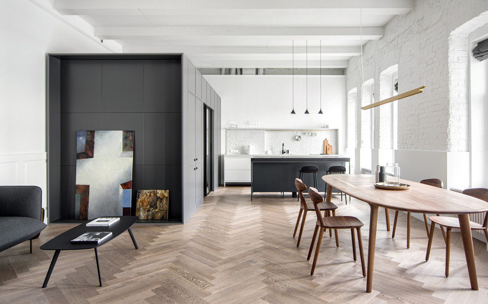 Inredning av ett modernt mellanstort vit linjärt vitt kök med öppen planlösning, med en undermonterad diskho, luckor med profilerade fronter, vita skåp, bänkskiva i kvarts, vitt stänkskydd, svarta vitvaror, mellanmörkt trägolv, en köksö och brunt golv