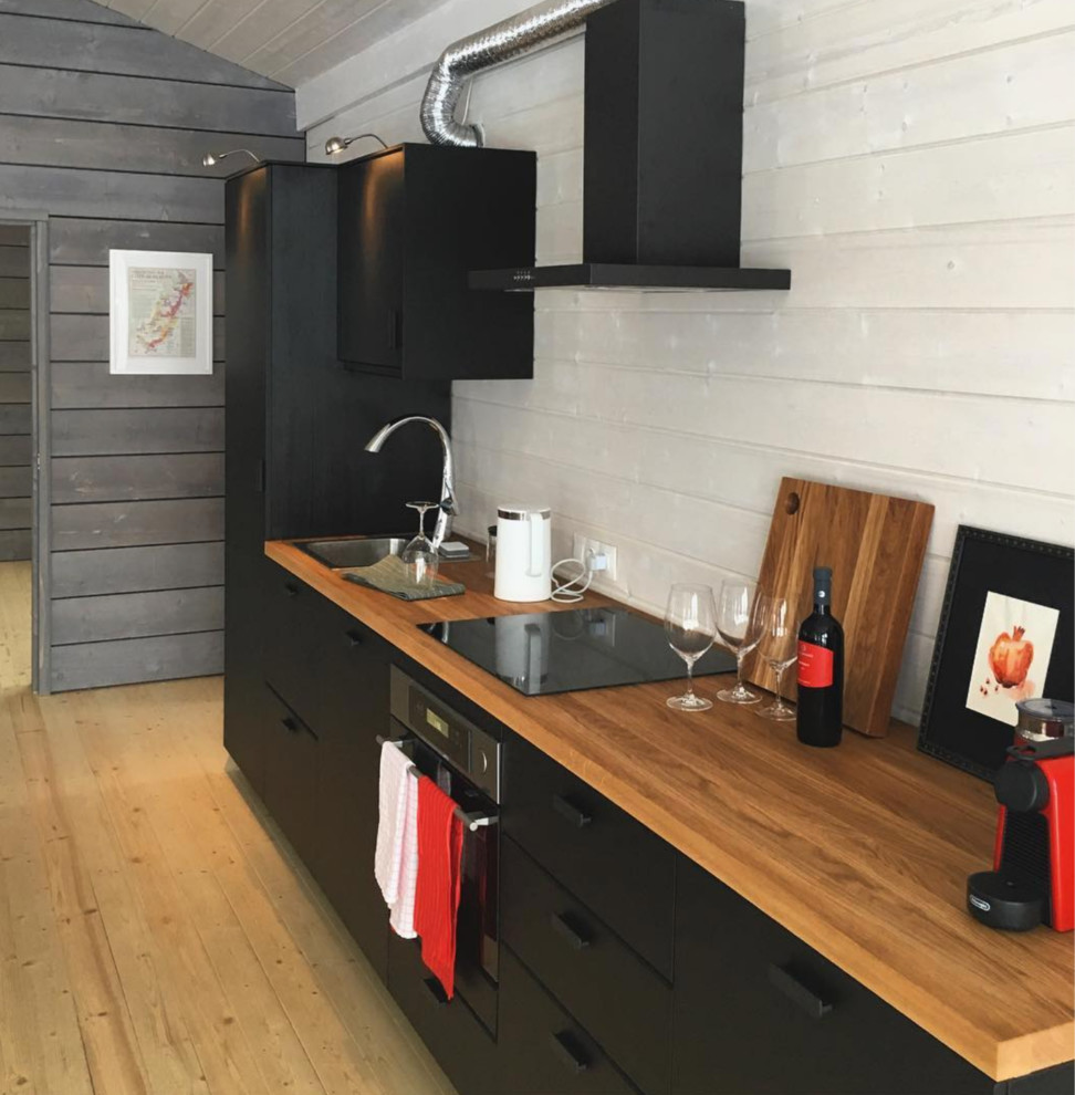 Immagine di una piccola cucina scandinava con ante lisce, ante nere, top in legno, paraspruzzi bianco, paraspruzzi in legno e top beige