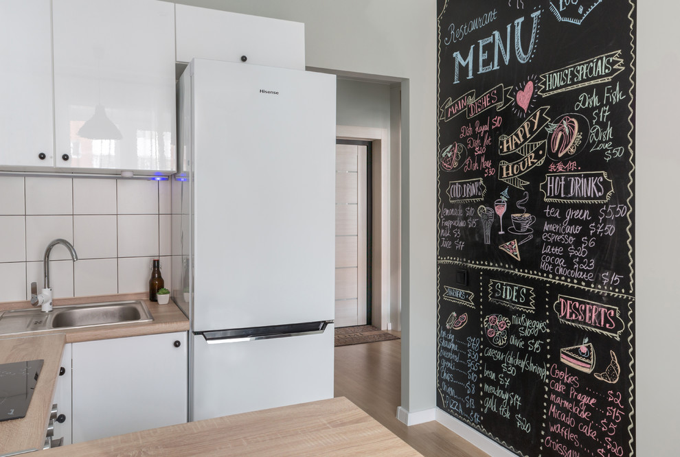 Small danish u-shaped eat-in kitchen photo in Other with a drop-in sink, flat-panel cabinets, white cabinets, white backsplash, a peninsula and beige countertops