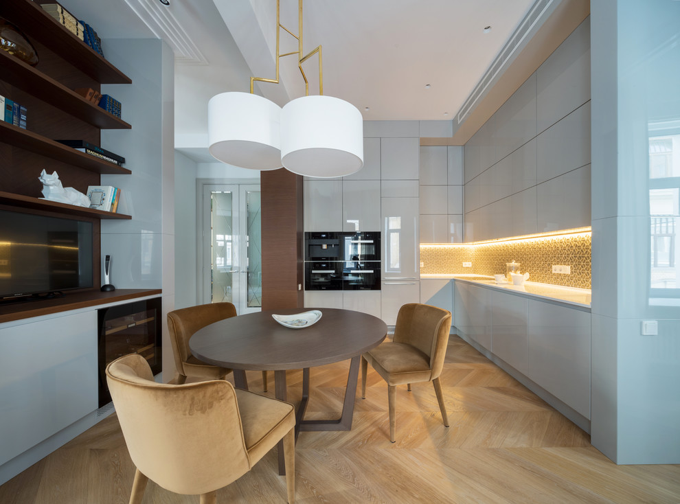 Example of a mid-sized trendy l-shaped light wood floor eat-in kitchen design in Moscow with a single-bowl sink, flat-panel cabinets, gray cabinets, quartzite countertops, metallic backsplash, mosaic tile backsplash, black appliances and no island