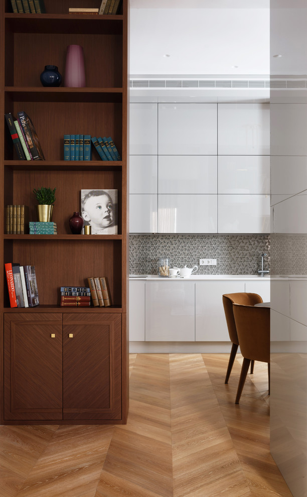 Exempel på ett mellanstort modernt kök, med en enkel diskho, släta luckor, grå skåp, bänkskiva i kvartsit, stänkskydd med metallisk yta, stänkskydd i mosaik, svarta vitvaror och ljust trägolv