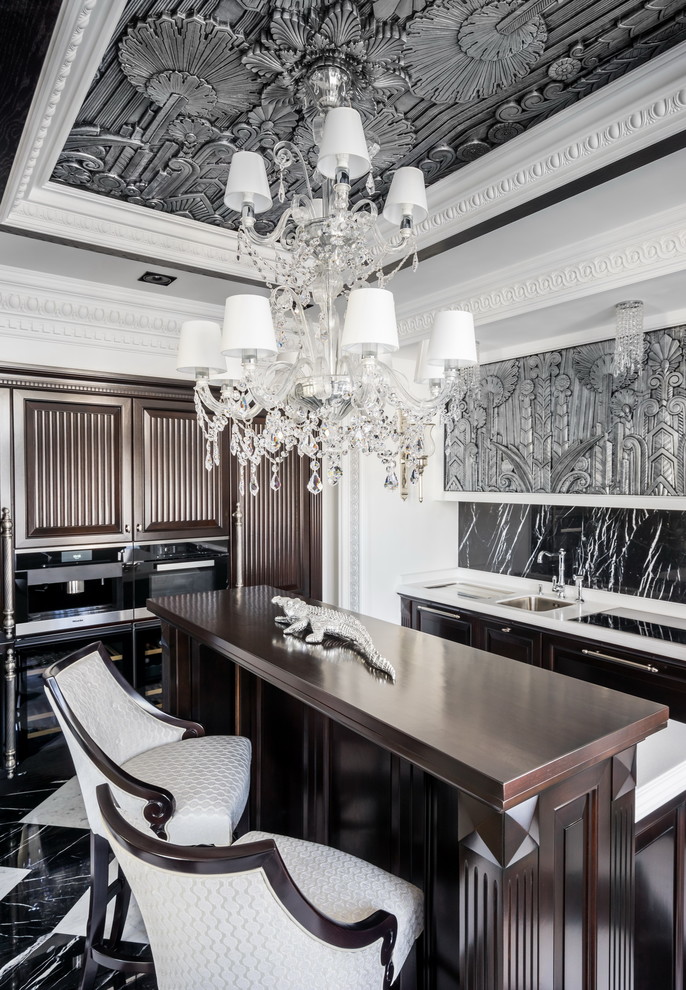 サンクトペテルブルクにあるトラディショナルスタイルのおしゃれなアイランドキッチン (アンダーカウンターシンク、黒いキッチンパネル、黒い調理設備、大理石の床、茶色いキャビネット、マルチカラーの床) の写真
