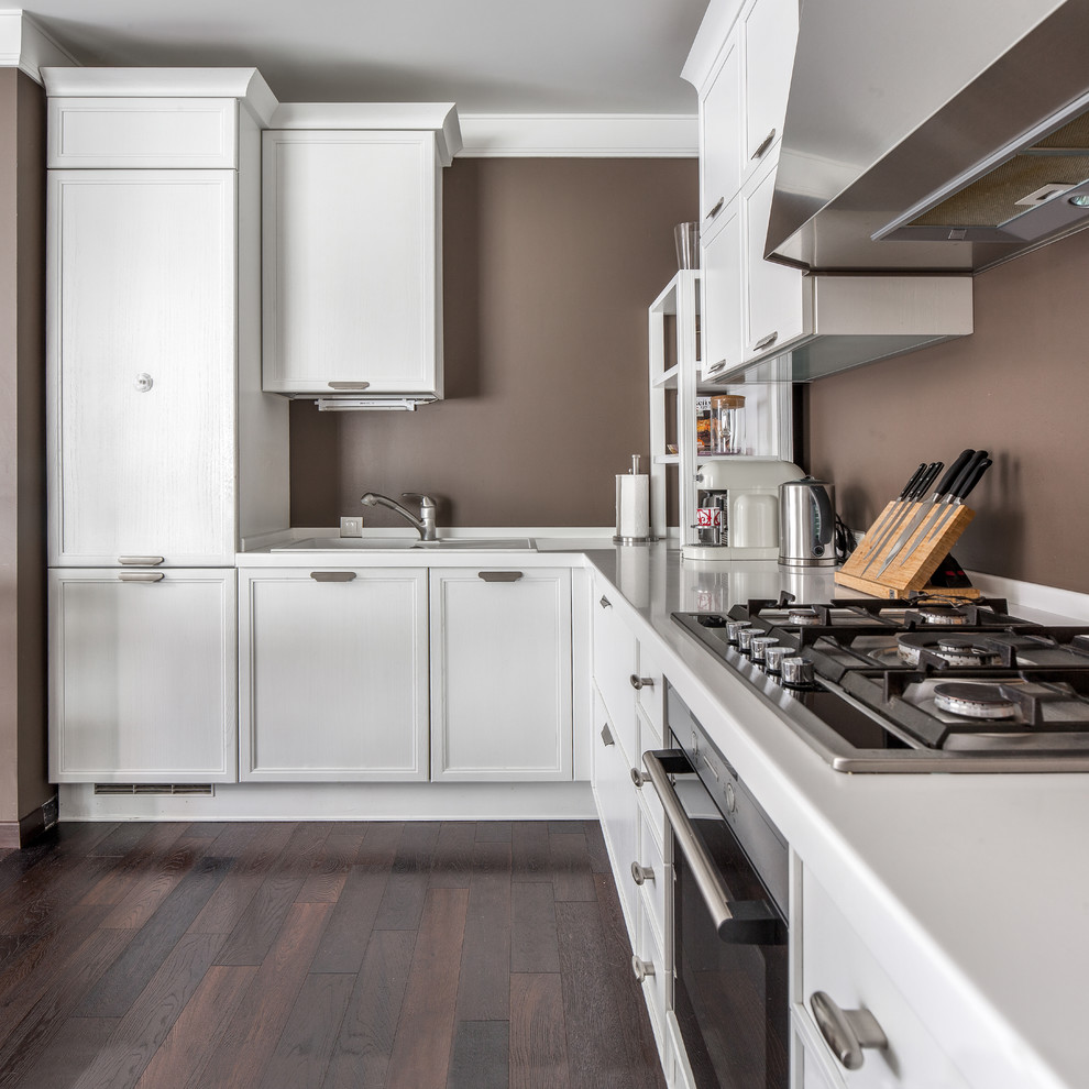 Exempel på ett stort modernt kök, med vita skåp, bänkskiva i koppar, rostfria vitvaror, mörkt trägolv, luckor med infälld panel, en nedsänkt diskho och brunt stänkskydd