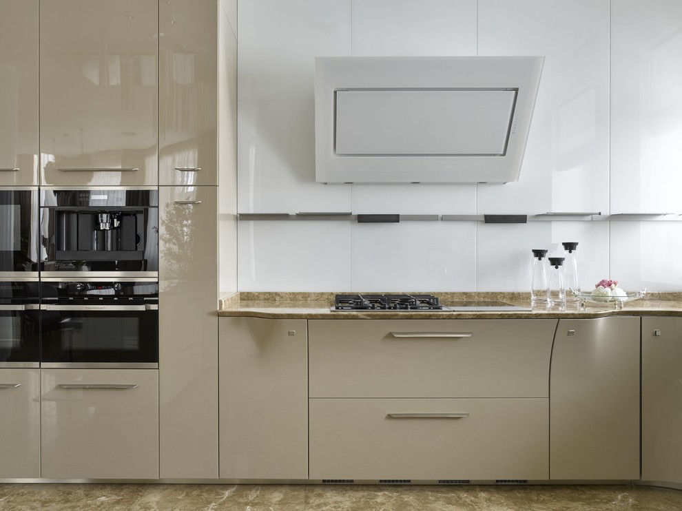 Inspiration for a large contemporary u-shaped kitchen/diner in Moscow with flat-panel cabinets, beige cabinets, marble worktops, white splashback, glass sheet splashback, black appliances, marble flooring, an island and beige floors.