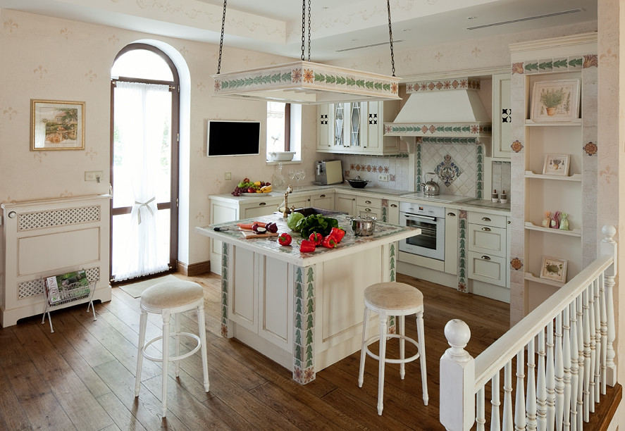 Immagine di una cucina shabby-chic style con lavello da incasso, ante con riquadro incassato, ante bianche, elettrodomestici bianchi e pavimento in legno massello medio