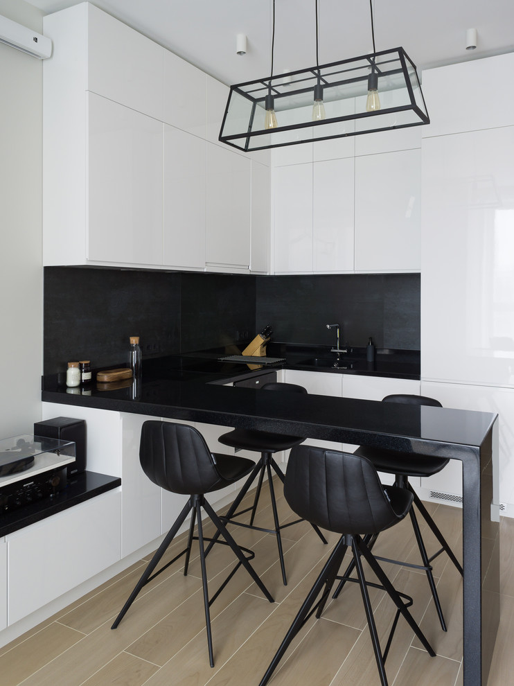 Inspiration för moderna svart u-kök, med släta luckor, vita skåp, svart stänkskydd, en halv köksö och beiget golv
