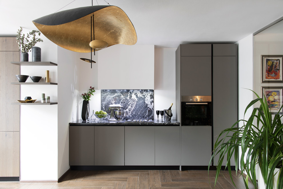 Einzeilige Moderne Küche mit flächenbündigen Schrankfronten, grauen Schränken und Küchengeräten aus Edelstahl in Sonstige
