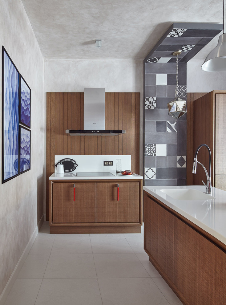 Ejemplo de cocina actual con fregadero integrado, armarios con paneles lisos, puertas de armario marrones, salpicadero blanco y una isla