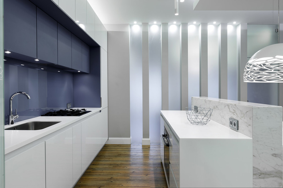 Идея дизайна: параллельная кухня-гостиная среднего размера в современном стиле с полом из линолеума, врезной мойкой, плоскими фасадами, белыми фасадами, синим фартуком и островом