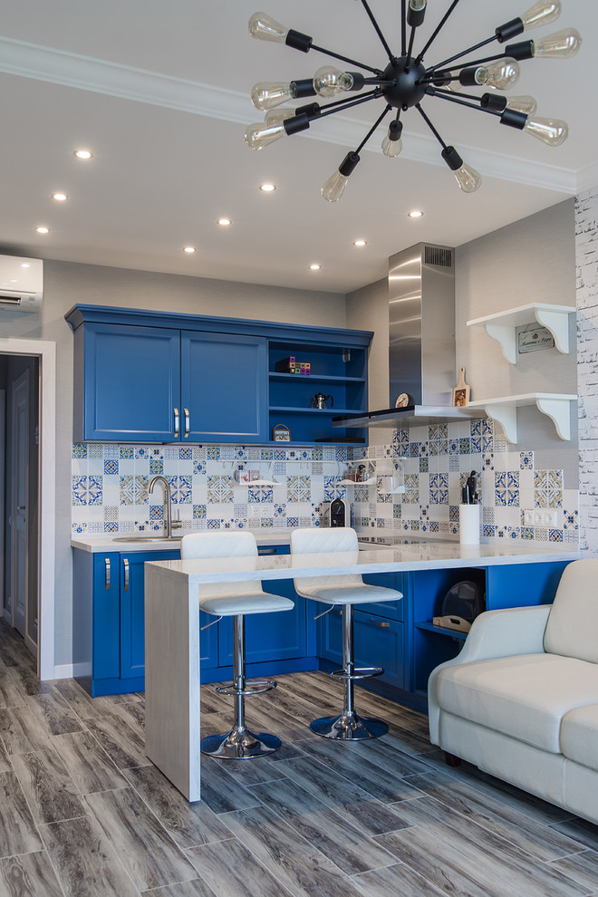 This is an example of a classic u-shaped kitchen/diner in Other with a built-in sink, shaker cabinets, blue cabinets and stainless steel appliances.