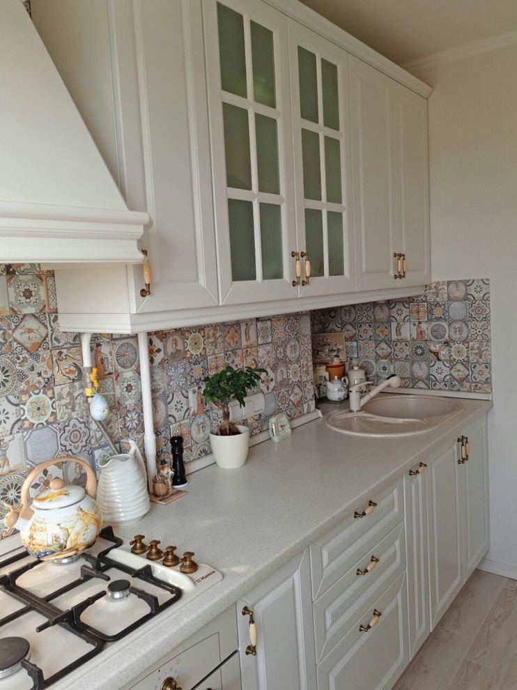 Inspiration for a small rural single-wall kitchen/diner in Other with a built-in sink, raised-panel cabinets, white cabinets, laminate countertops, multi-coloured splashback, white appliances and beige worktops.