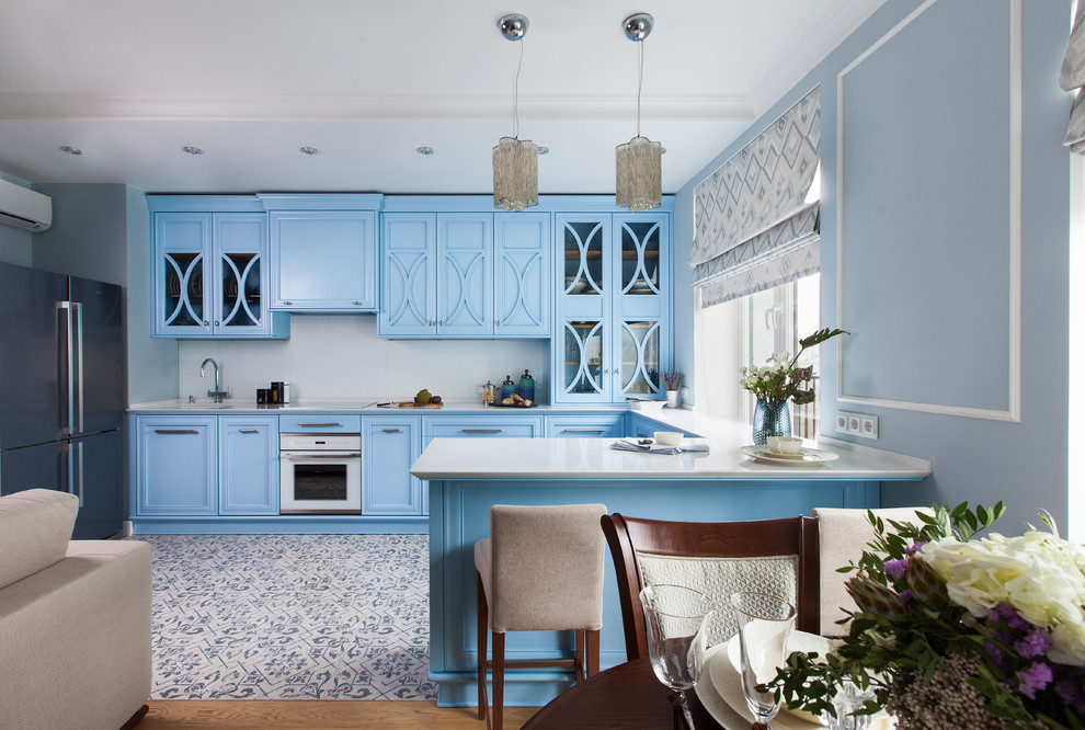 Klassische Küche in U-Form mit Schrankfronten mit vertiefter Füllung, blauen Schränken, Küchenrückwand in Weiß, Küchengeräten aus Edelstahl und weißer Arbeitsplatte in Moskau