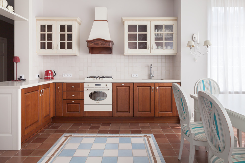 На фото: угловая кухня в классическом стиле с обеденным столом и полом из керамической плитки