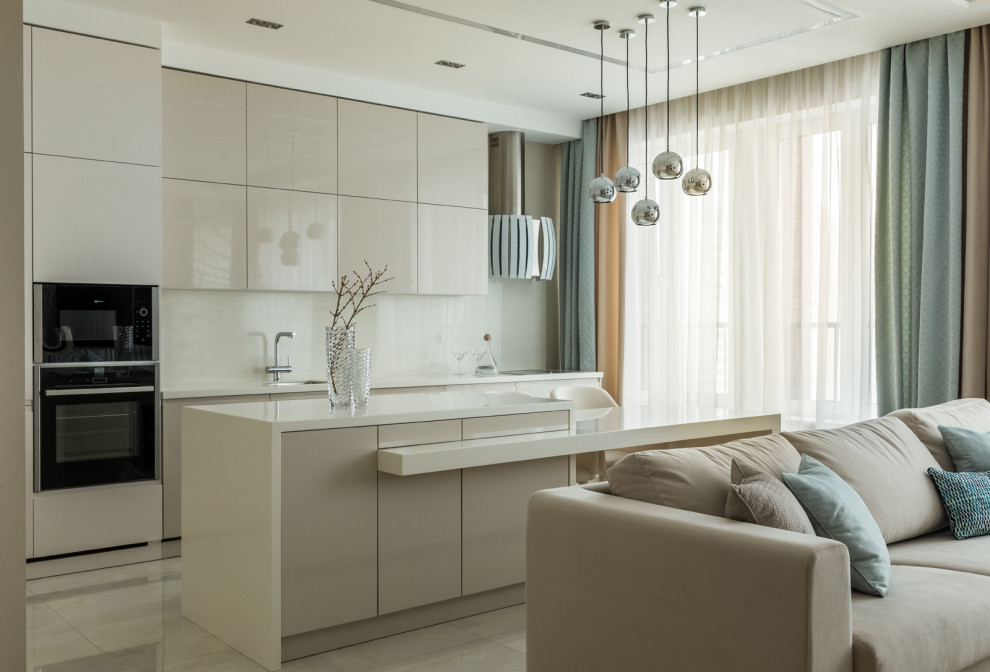 Inspiration for a large contemporary single-wall porcelain tile, beige floor and tray ceiling open concept kitchen remodel in Moscow with an undermount sink, flat-panel cabinets, beige cabinets, solid surface countertops, beige backsplash, black appliances, an island and beige countertops