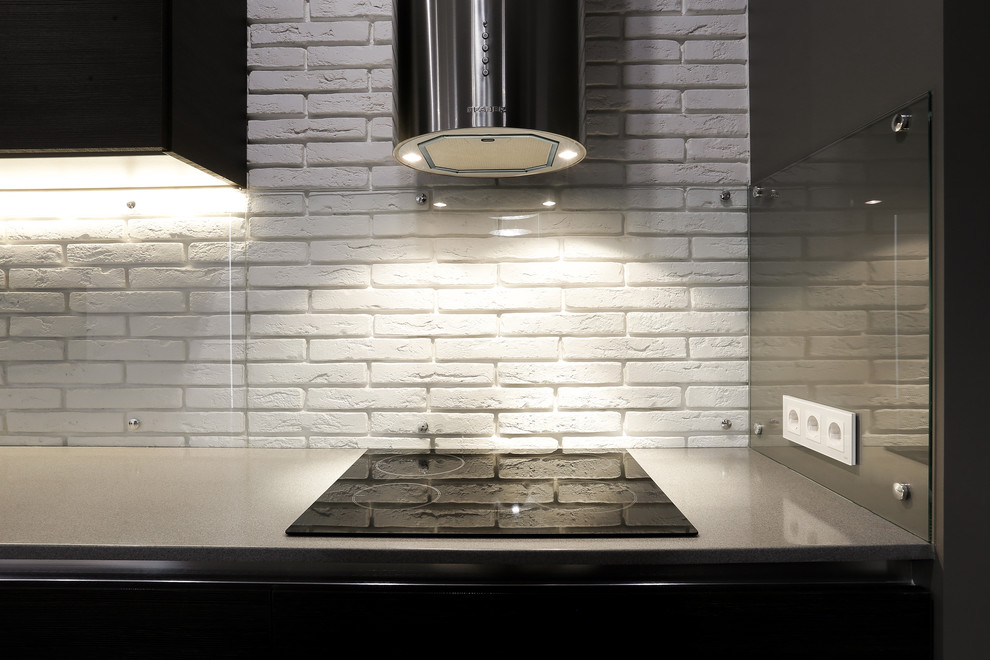 Cette image montre une cuisine ouverte linéaire design avec un placard à porte plane, une crédence blanche et une crédence en feuille de verre.