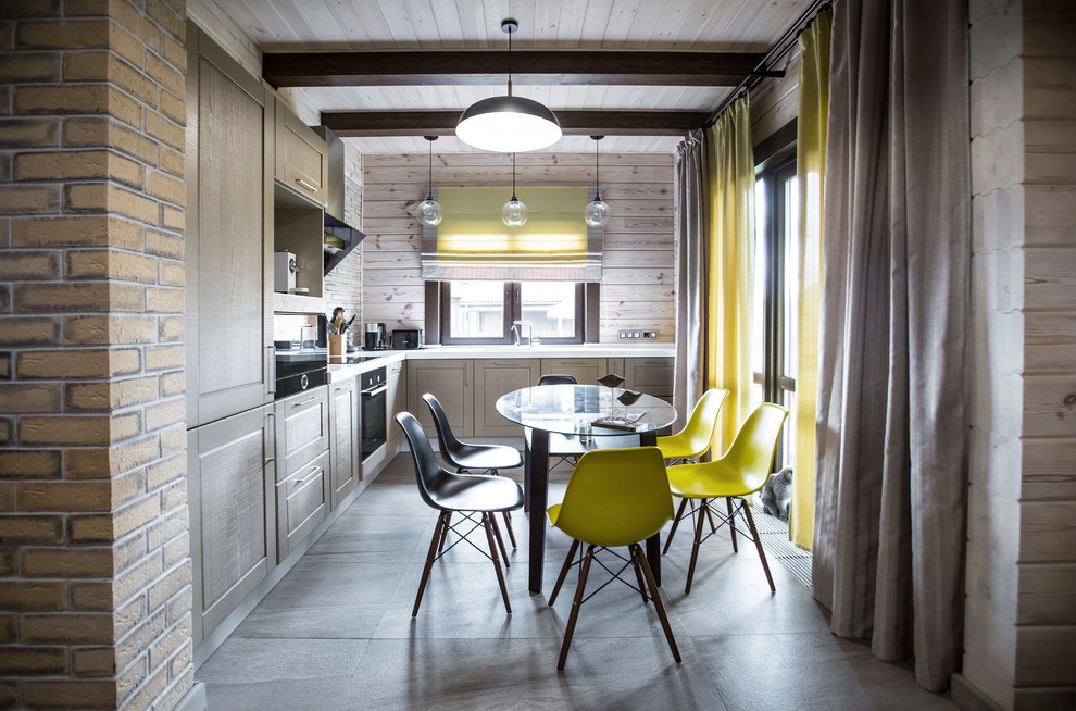 Свежая идея для дизайна: угловая кухня-гостиная в стиле неоклассика (современная классика) с фасадами в стиле шейкер, серыми фасадами, черной техникой и серым полом без острова - отличное фото интерьера
