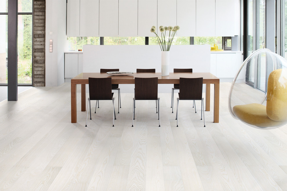 Immagine di una sala da pranzo aperta verso il soggiorno design con parquet chiaro e pavimento bianco
