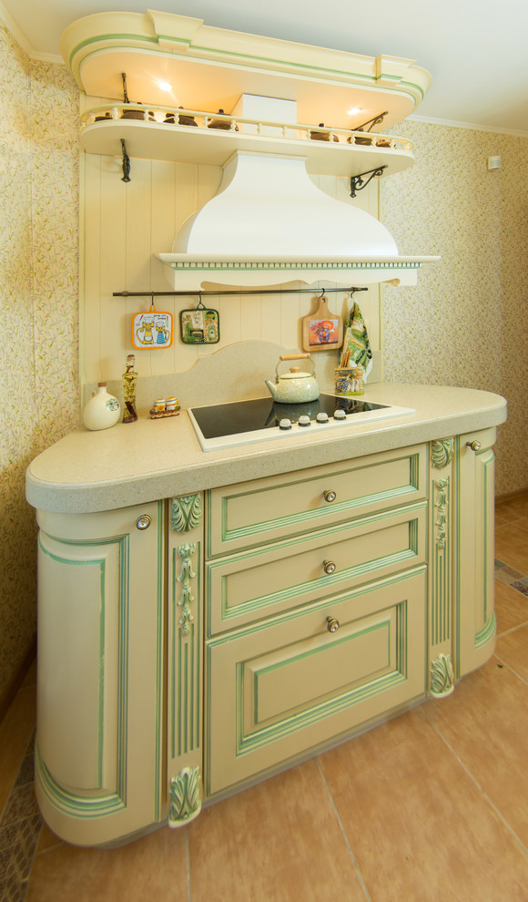 This is an example of a small traditional galley enclosed kitchen in Moscow with an integrated sink, raised-panel cabinets, beige cabinets, composite countertops, beige splashback, white appliances, ceramic flooring and no island.