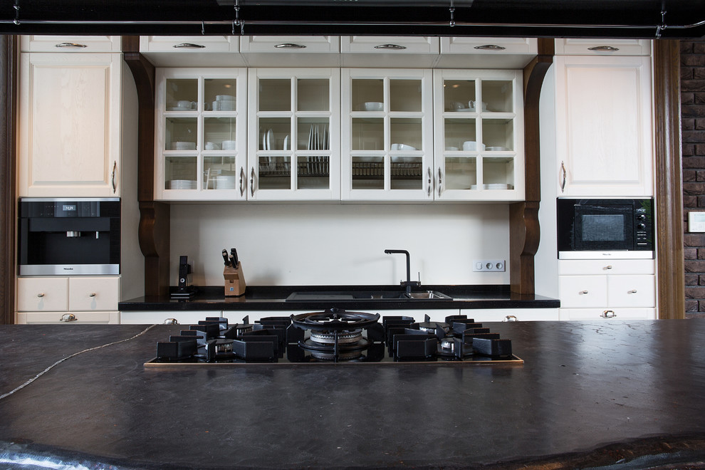 Foto på ett mycket stort funkis kök, med en dubbel diskho, släta luckor, skåp i rostfritt stål, kaklad bänkskiva, vitt stänkskydd, stänkskydd i keramik, svarta vitvaror, marmorgolv, en köksö och grått golv