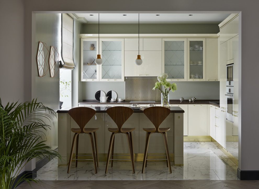 Inspiration for a transitional l-shaped porcelain tile and white floor open concept kitchen remodel in Other with a drop-in sink, flat-panel cabinets, quartzite countertops, gray backsplash, metal backsplash, white appliances, an island, brown countertops and beige cabinets