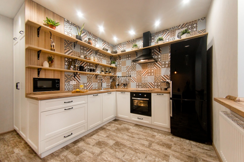 Idéer för att renovera ett mellanstort skandinaviskt kök, med en nedsänkt diskho, luckor med infälld panel, vita skåp, träbänkskiva, flerfärgad stänkskydd, stänkskydd i keramik, svarta vitvaror, klinkergolv i keramik och beiget golv