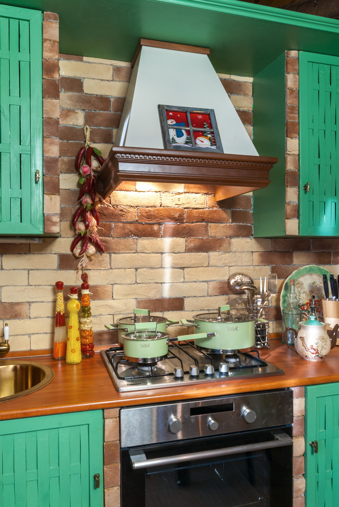 Immagine di una piccola cucina lineare country con ante verdi, top in laminato, paraspruzzi beige e paraspruzzi con piastrelle in pietra