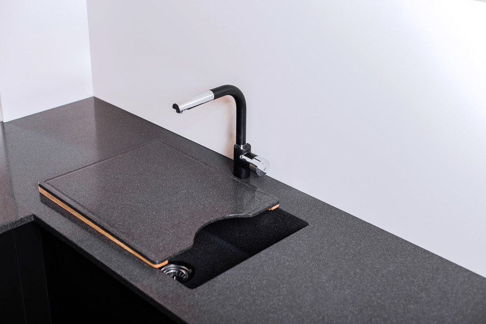 Esempio di una cucina ad U design con lavello sottopiano, ante lisce e top in superficie solida
