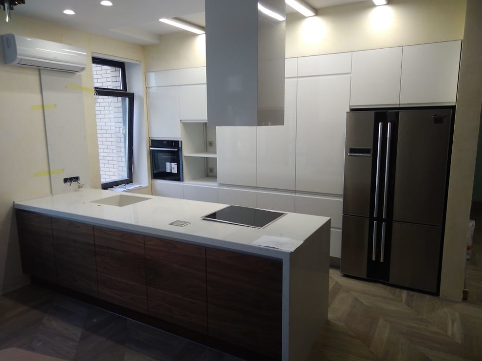 Large urban galley eat-in kitchen photo in Other with an undermount sink, flat-panel cabinets, medium tone wood cabinets, quartz countertops, stainless steel appliances, an island and white countertops