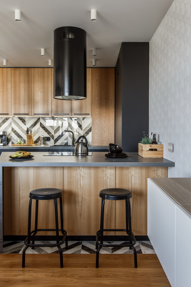 Moderne Küche mit Einbauwaschbecken, hellen Holzschränken, bunter Rückwand, Halbinsel, grauer Arbeitsplatte und Tapete in Sonstige