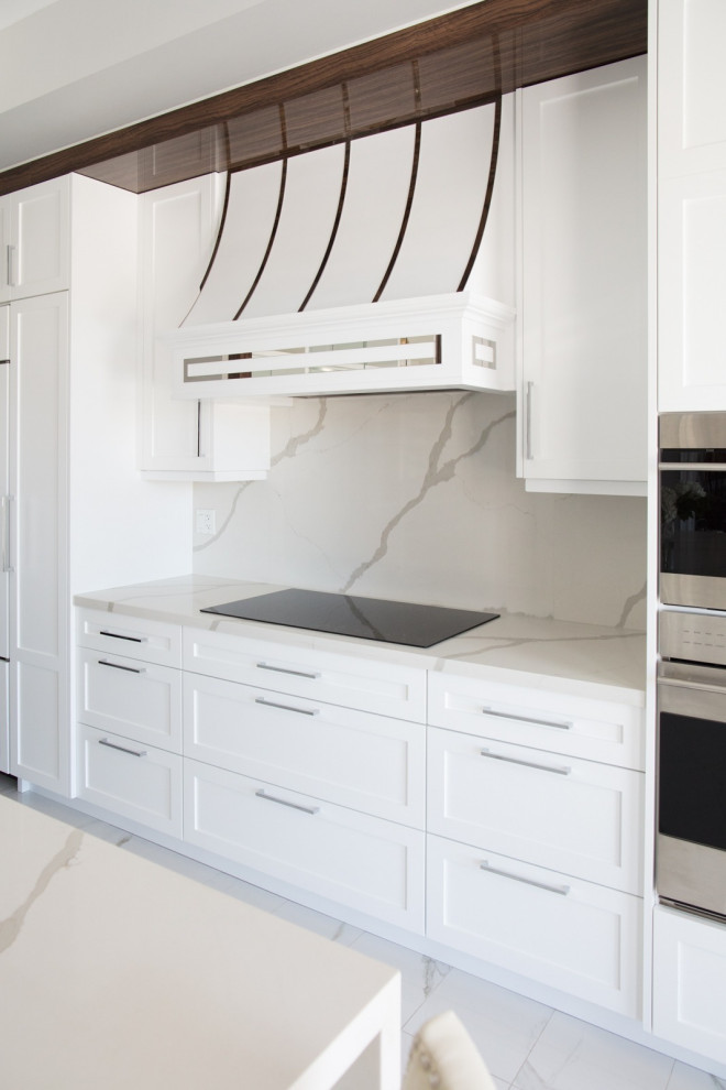 Foto på ett stort vintage vit linjärt kök och matrum, med en dubbel diskho, luckor med infälld panel, vita skåp, bänkskiva i kvarts, vitt stänkskydd, integrerade vitvaror, klinkergolv i keramik, en köksö och vitt golv